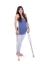 Full length portrait of a smiling pregnant woman using crutch