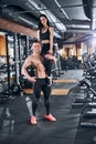Happy topless bodybuilder lifting girlfriend in gym
