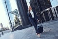 Full length portrait of a smiling successful businesswoman pulling suitcase Royalty Free Stock Photo