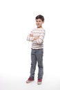 Full-length portrait of a smiling teenager boy  with arms crossed against white background in studio Royalty Free Stock Photo