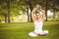 Full length portrait of smiling woman sitting in lotus pose Royalty Free Stock Photo