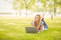 Full length portrait of smiling woman using laptop at park Royalty Free Stock Photo
