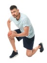 Full length portrait of sportsman having knee problems on white