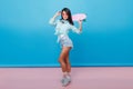 Full-length portrait of sporty girl wears cute socks and stylish cotton shirt. Slim brunette latin woman with skateboard Royalty Free Stock Photo