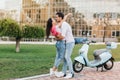 Full-length portrait of sporty man posing with lovely brunette girl with lawn on background. Graceful slim lady in Royalty Free Stock Photo