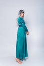 Full length portrait of a standing back princess in a medieval, fantasy, turquoise dress with ash hair and a silver crown