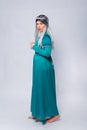 Full length portrait of a standing back princess in a medieval, fantasy, turquoise dress with ash hair and a silver crown