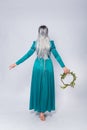 Full length portrait of a standing back princess in a medieval, fantasy, turquoise dress with ash hair and a silver crown