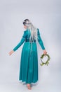 Full length portrait of a standing back princess in a medieval, fantasy, turquoise dress with ash hair and a silver crown