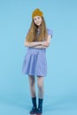 Full Length Portrait of Still Caucasian Teenage Girl In Long Blue Dress, Wellington Rubber Boots Posing In Winter Hat With Hands Royalty Free Stock Photo