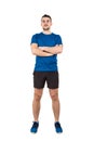 Full length portrait of strong man professional athlete keeps arms crossed, wearing blue t-shirt and black shorts looking