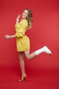 Cheerful beautiful woman in yellow dress having fun with plaster on her leg. Royalty Free Stock Photo