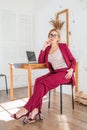 Beautiful clever business woman sitting at the table at workstation with laptop Royalty Free Stock Photo