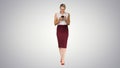 Successful female employer typing text message on her cellphone while walking on gradient background. Royalty Free Stock Photo