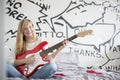 Full-length portrait of teenage girl playing guitar in bedroom Royalty Free Stock Photo