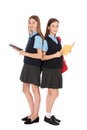 Full length portrait of teenage girls in school uniform with books on white Royalty Free Stock Photo