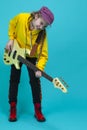 Full Length Portrait of Teenager Guitar Musician Playing On Yellow Bass Guitar Posing In Fashionable Yellow Hoody Jacket Over