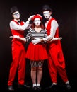 Full length portrait of three mime artists, isolated on black background. Woman and two men stand side by side Royalty Free Stock Photo