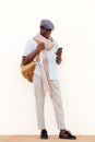 Full length trendy young black guy looking at cell phone and smiling Royalty Free Stock Photo