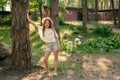 Full-length portrait of tween girl leaning of tree in courtyard of country house in summer Royalty Free Stock Photo