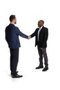 Full-length portrait of two businessmen, partners shaking hads due to successful business deal isolated over white Royalty Free Stock Photo