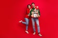 Full length portrait of two cheerful funky partners embrace hold pile stack festive giftbox isolated on red color