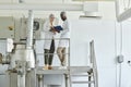 Two workers wearing lab coats in factory workshop Royalty Free Stock Photo