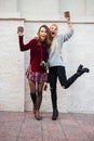 Full length portrait of two young girls with coffee cups