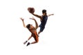 Full-length portrait of two young men, professional basketball players in motion, in a jump throwing a ball isolated Royalty Free Stock Photo