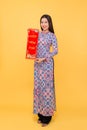 Full-length portrait of Vietnamese girl in ao-dai dress showing