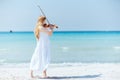 Full length portrait of woman in dress enjoying playing on beach Royalty Free Stock Photo