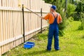 Full-length portrait of worker painting a wooden wall with paint roller. Royalty Free Stock Photo