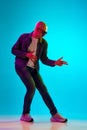 Full-length portrait of young bald man with moustache wearing casual clothes, posing against blue studio background in Royalty Free Stock Photo