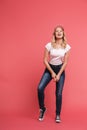 Full length portrait of young blond woman 20s wearing casual jeans and sneakers smiling at camera Royalty Free Stock Photo