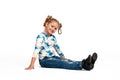 Studio portrait of young blonde smiling girl sitting on the floor against white background Royalty Free Stock Photo