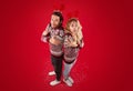 Full length portrait of young couple in Christmas sweaters shivering over red background, above view Royalty Free Stock Photo