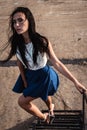 Portrait of young fashionable brunette woman practicing model posing outdoors against urban style background of grey concrete wall Royalty Free Stock Photo