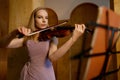Full-length portrait of young female violinist playing fiddle