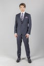 Full length portrait on young handsome man. Elegant businessman in suit isolated on a grey background. Royalty Free Stock Photo