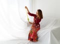 Muslim girl celebrates end of Ramadan, dressed in red kebaya dress, holding ketupat food