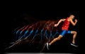 Full-length portrait of young male athlete, professional runner in motion over black background. Developing