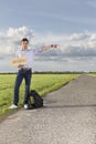 Full length portrait of young man with anywhere sign gesturing on countryside