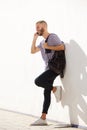 Full length young man leaning against wall talking on cell phone Royalty Free Stock Photo