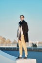 Full length portrait of young man in old wool coat, scarf and short trousers outdoor Royalty Free Stock Photo