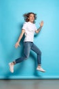 Full-length portrait of young man, student in casual style outfit jumping  on blue background. Human emotions Royalty Free Stock Photo