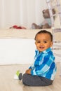 Full length portrait of a young mixed race boy sitting on the floor. Royalty Free Stock Photo