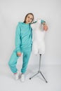 Full length portrait of young sporty fitness women in blue cotton hooded sweatsuit casual outfit playing with dummy