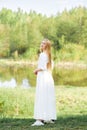 Full length portrait of young woman in long dress on river bank Royalty Free Stock Photo