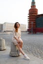 Full length portrait of a young woman with red hair, wear in beige elegant dress, behinde Kremlin red square in Moscow Royalty Free Stock Photo