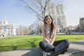 Full length portrait of young woman sitting against Westminster Abbey in London, England, UK Royalty Free Stock Photo